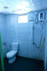 a bathroom with a white toilet and a shower at MENAKA HOMESTAY in Tangalle