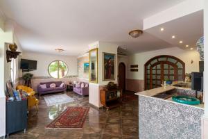 a kitchen and living room with purple furniture at Hotel Alexander in Giardini Naxos +96 photos