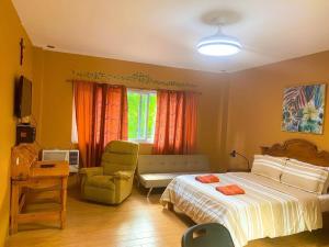 a bedroom with a bed and a chair and a window at Pulangbato Falls Mountain Resort in Dumaguete +59 photos