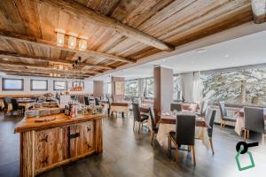 a restaurant with wooden ceilings and tables and chairs at Hotiday Sestriere Ski Run in Sestriere