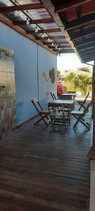 a patio with a table and chairs on a deck at casa no paraíso do Capri in São Francisco do Sul