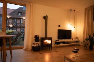 a living room with a fireplace and a television at An der Kirchtreppe in Blankenburg