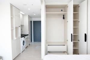 a bedroom with white walls and a closet at The Hide City in Jeju