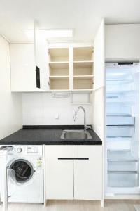 a white kitchen with a sink and a dishwasher at The Hide City in Jeju +60 photos