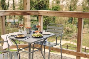 a table with two plates of food and glasses of wine at The Fish Hotel in Broadway