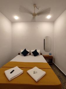 a bedroom with a bed with two towels on it at Om Coast Gokarna in Gokarna