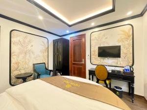 a bedroom with a bed and a desk and a television at Capital CauGiay Hotel in Hanoi