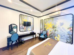 a bedroom with a bed and a desk and a tv at Capital CauGiay Hotel in Hanoi