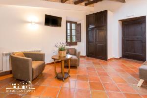 a living room with chairs and a table at Masia Can Canyes & Spa in San Lorenzo de Hortóns