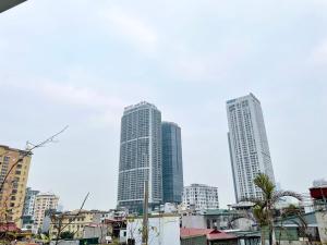 two tall buildings in a city with buildings at Capital CauGiay Hotel in Hanoi