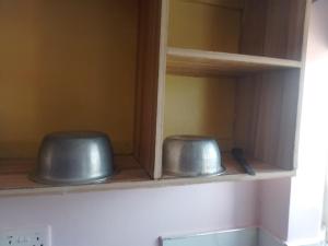 two bowls sitting on a shelf in a kitchen at Masqani studios muthiga in Rungiri +64 photos