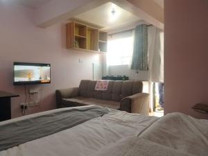 a living room with a couch and a tv at Masqani studios muthiga in Rungiri