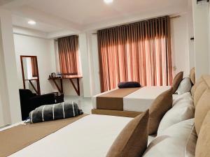 a hotel room with two beds and a window at Diyon'S Lodge in Ella