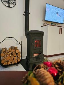 a stove with a pile of wood in a room at Zöld Vendégház - Siklós in Siklós