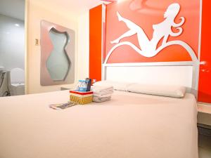 a bedroom with a bed and a painting on the wall at Astrotel Monumento in Manila