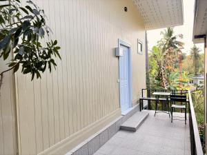 a balcony with a blue door and a table and chairs at Koh Kood BED's in Ko Kood