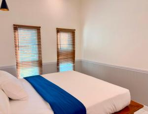 a bedroom with a bed and two windows at Koh Kood BED's in Ko Kood