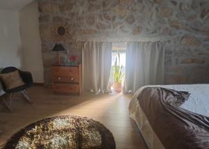 a bedroom with a bed and a chair and a window at Cantinho do Ribeiro in Lourosa da Trapa