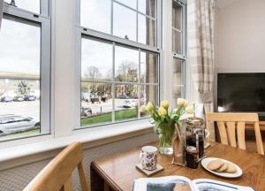 a dining room with a table with flowers and a window at Mabels View in Melrose
