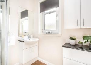 a white bathroom with a sink and a mirror at Mabels View in Melrose +11 photos