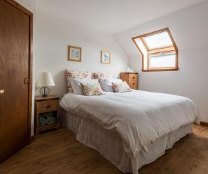 ein Schlafzimmer mit einem großen weißen Bett und einem Fenster in der Unterkunft Abbey Mill in Melrose