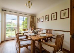 ein Esszimmer mit Tisch und Stühlen und einem Fenster in der Unterkunft Abbey Mill in Melrose