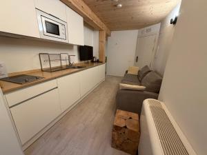 a living room with a couch and a kitchen at Pensión ARISTONDO Boutique Pentsioa in Getaria +33 photos