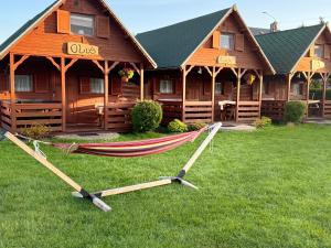 a hammock in the grass in front of a lodge at Pokoje i Domki Nadmorskie - Bajkowa Mierzeja in Stegna +58 photos