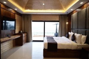 a bedroom with a large bed and a television at Namaste Corbett Resort and Spa in Jāmb