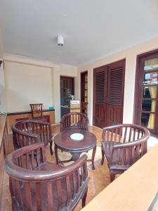 a living room with wooden chairs and a table at Irma Guest House Syariah in Temenggungan