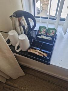 a tea pot and cups sitting on a window sill at Ynyscedwyn Arms in Ystradgynlais