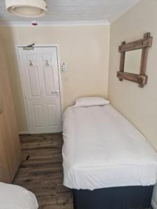 a small room with two beds and a door at Ynyscedwyn Arms in Ystradgynlais +2 photos