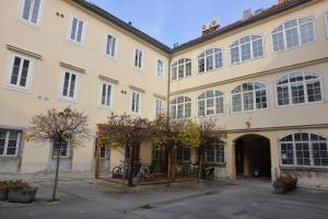 a large yellow building with a courtyard at AMS Rooms in Ljubljana