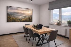 ein Esszimmer mit einem Tisch, auf dem ein Laptop steht in der Unterkunft FalHouse- luksusowe apartamenty z jacuzzi & sauna in Lesko + 9 Fotos