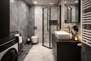 ein Badezimmer mit Waschbecken und Dusche in der Unterkunft FalHouse- luksusowe apartamenty z jacuzzi & sauna in Lesko