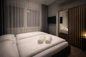 ein Schlafzimmer mit einem weißen Bett, auf dem Handtücher liegen in der Unterkunft FalHouse- luksusowe apartamenty z jacuzzi & sauna in Lesko