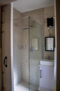 a bathroom with a glass shower and a sink at Dawn's Place in Harare +11 photos