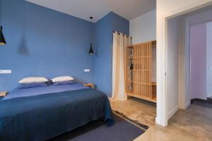 a bedroom with blue walls and a bed with pillows at Casa Langlois in Telde