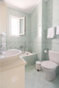 a bathroom with a sink and a toilet and a tub at Chios Seafront Luxury Villa with Pool in Chios +21 photos