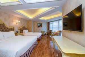 a hotel room with two beds and a flat screen tv at 泽润大酒店 in Chengdu
