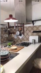 a kitchen with a counter with plates and a stove at Agriturismo La Casa Nel Bosco in Boveglio