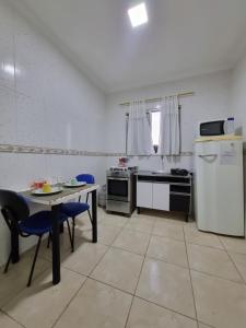a kitchen with a table and chairs and a refrigerator at Loft em Butantã, próximo a USP in São Paulo