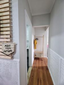 a hallway with white walls and wood floors at Loft em Butantã, próximo a USP in São Paulo