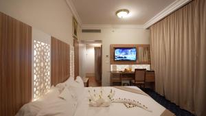 a bedroom with a bed and a desk and a television at ASTONEAST TAIBA Hotel in Medina
