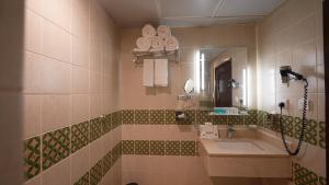 a bathroom with a sink and a mirror at ASTONEAST TAIBA Hotel in Medina +26 photos