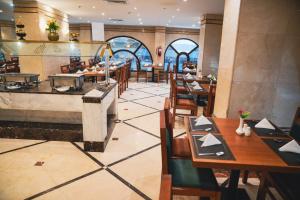 a restaurant with tables and chairs and a counter at ASTONEAST TAIBA Hotel in Medina