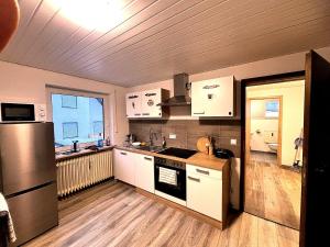 a kitchen with white cabinets and a large window at Room4U in Memmingen