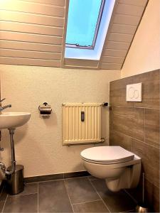 a bathroom with a toilet and a sink at Room4U in Memmingen +7 photos