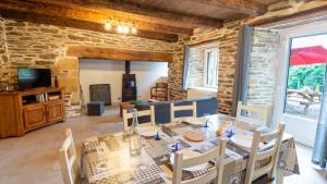 a dining room with a table and chairs and a tv at Gîte de montredon in Cubières