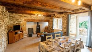 a living room with a table and chairs and a tv at Gîte de montredon in Cubières